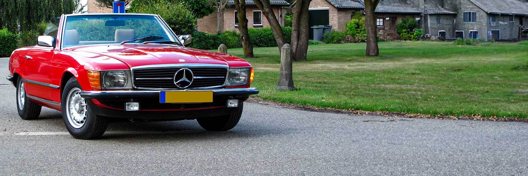 Banner image of a  Mercedes SL R107 featuring original Mercedes wheels.
