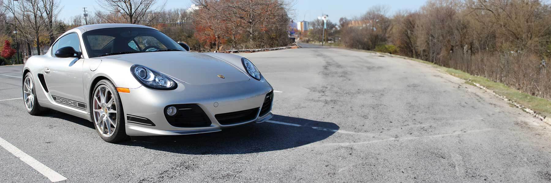 Banner image of a  Porsche Cayman 987C featuring original Porsche wheels.