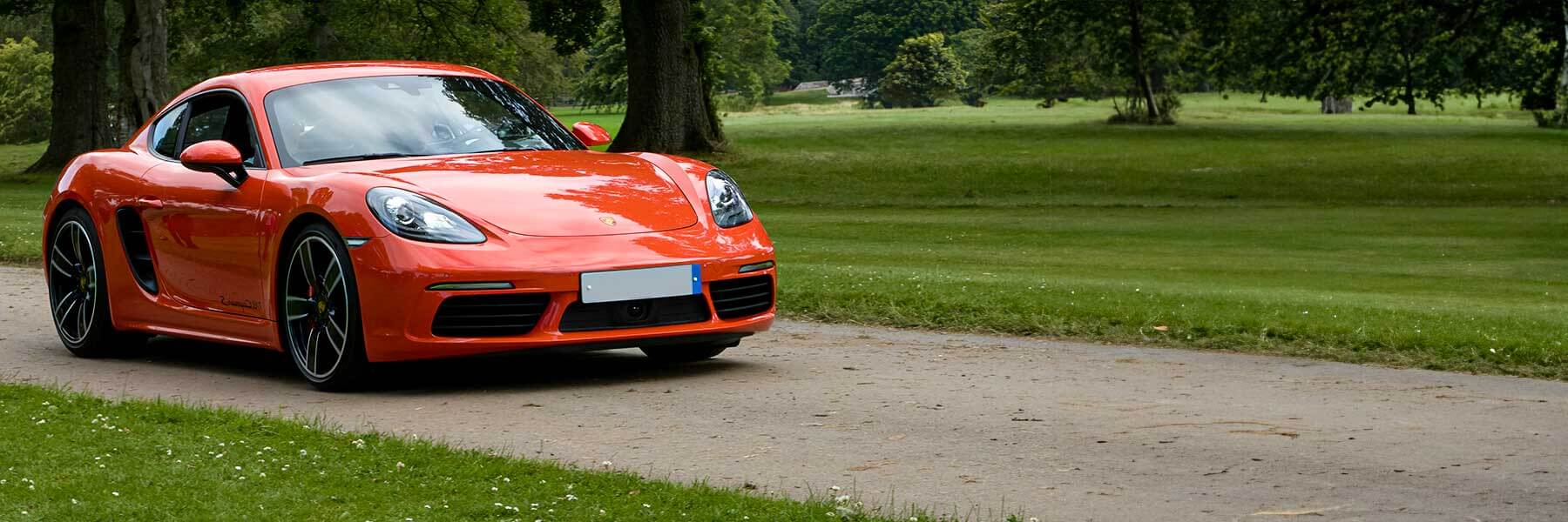 Banner image of a  Porsche 718 Cayman 982C featuring original Porsche wheels.